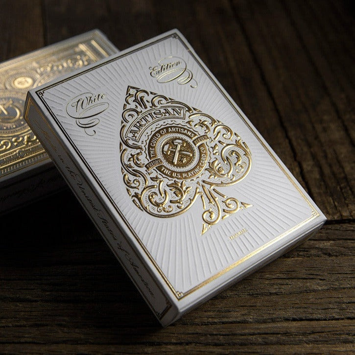 White and gold playing card box on a wooden surface