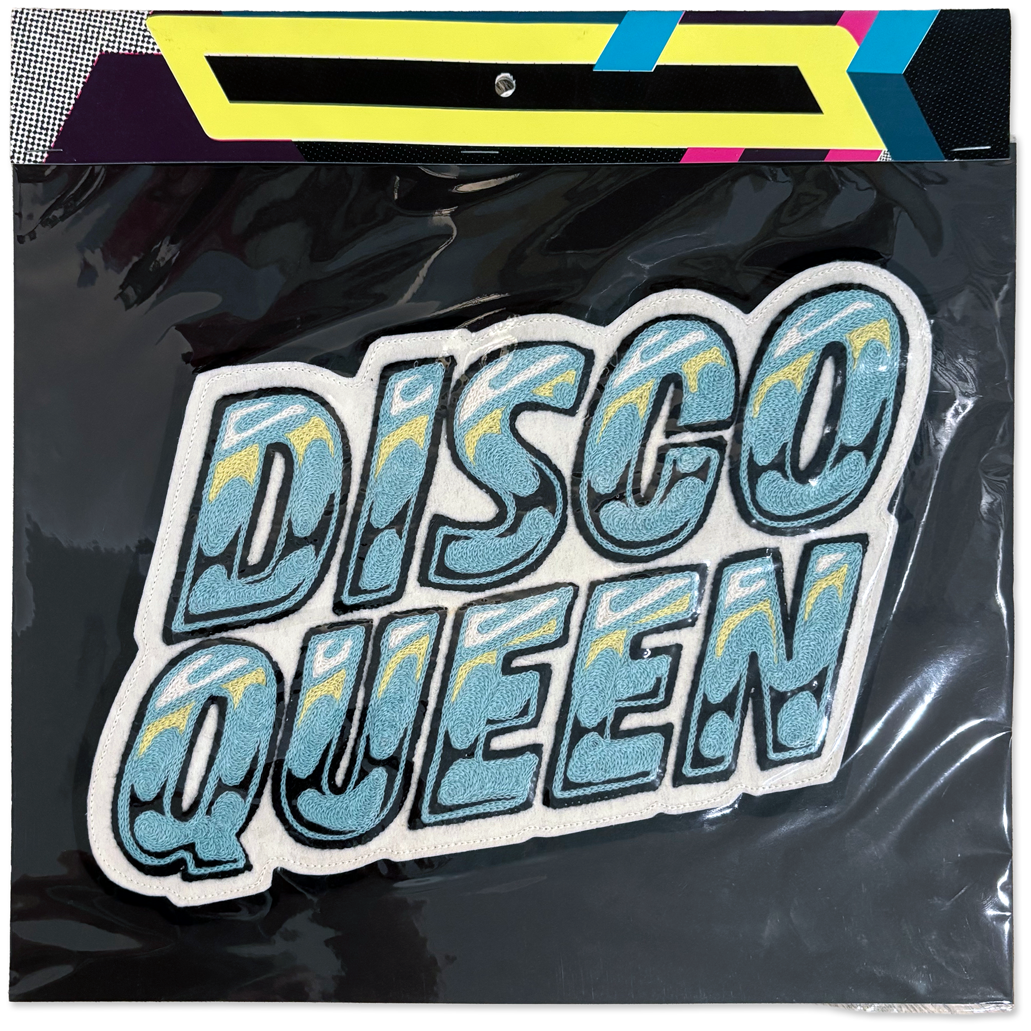 A 'DISCO QUEEN' embroidered patch with a glittery light blue and yellow patterned fill, outlined in white and black, shown inside its clear plastic packaging with a colorful header card.