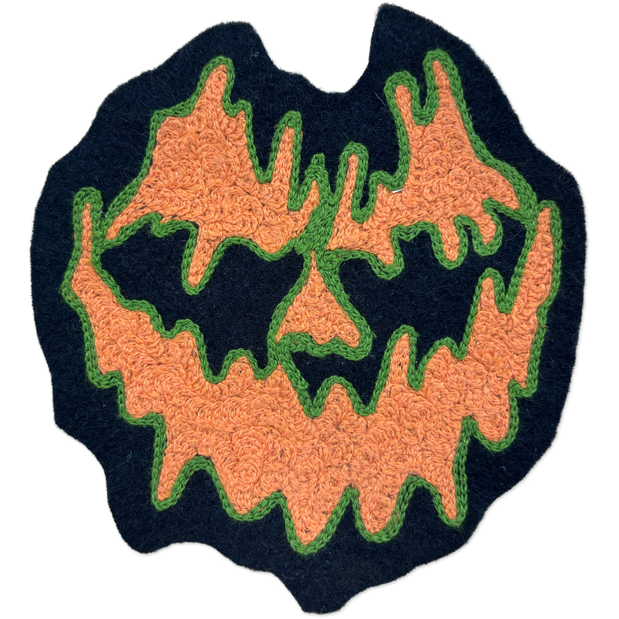 A Halloween-themed chainstitch patch featuring a spooky jack-o'-lantern face. The design has a dark navy blue base, orange textured facial features, and green stitched outlines, presented on a clean white background.