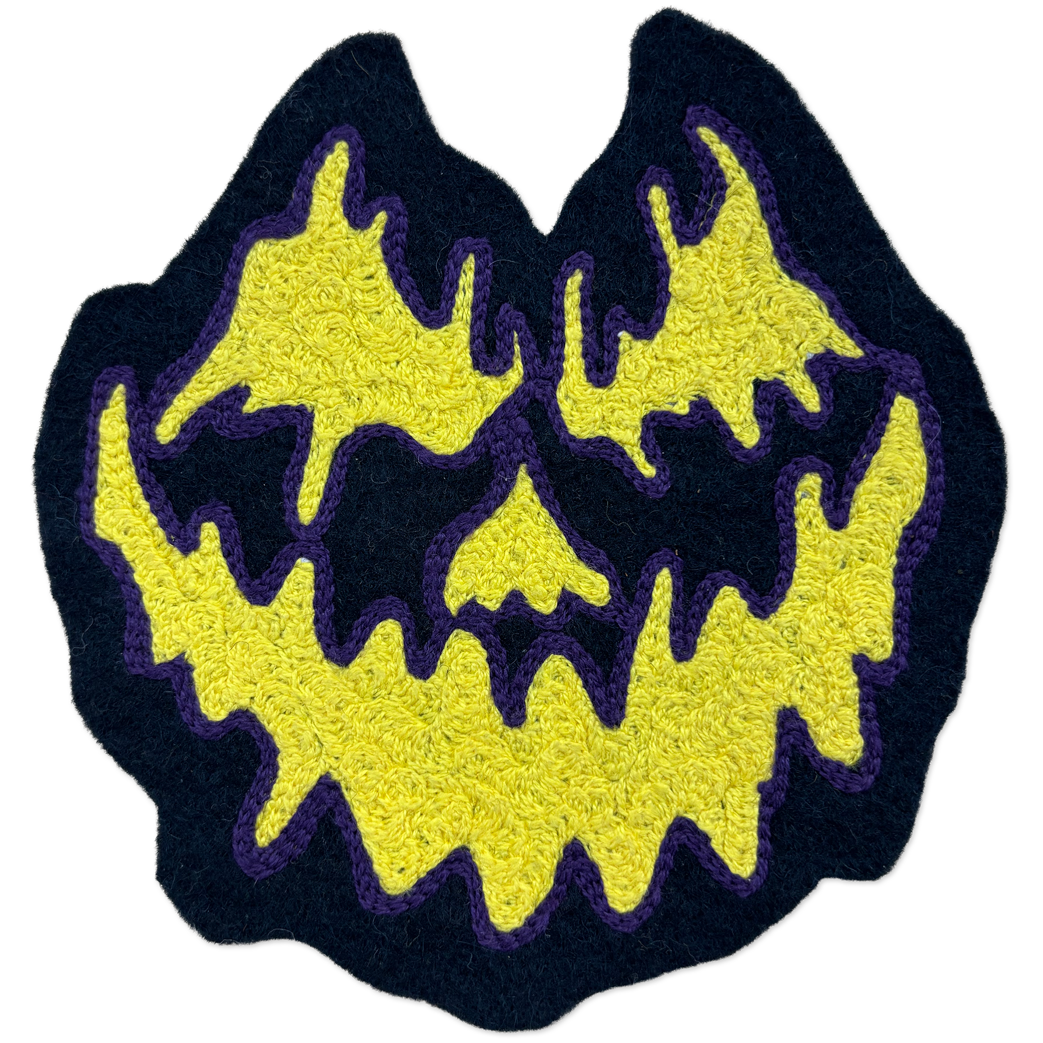 A chainstitch patch shaped like a jack-o'-lantern face, featuring a bright yellow textured design with a dark navy blue border and purple stitched outlines, isolated on a white background.