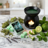 Wax melter with green wax and 'Enchanted Forest' wax melts packaging on a marble surface with greenery.