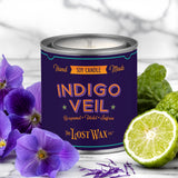 Candle labeled 'Indigo Veil' by The Lost Wax Co. with purple flowers and a lime on a white background