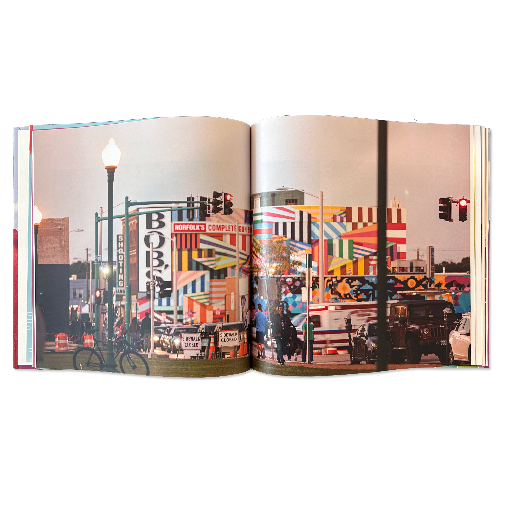 double-page spread of a photograph of an urban scene including buildings with colorful murals painted on them.
