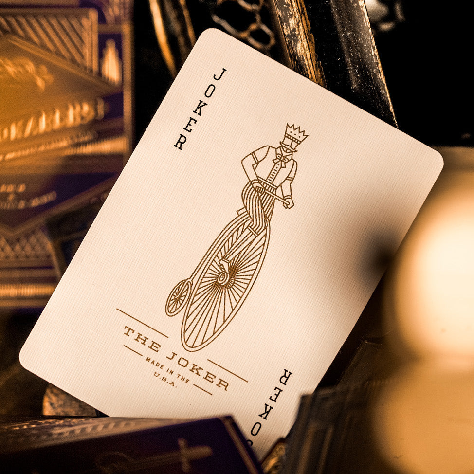 Playing card featuring 'The Joker' design on a dark background with blurred objects.