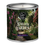 An unlit candle in a tin labeled "The Walled Garden"