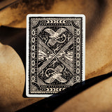 Back of Voyager playing cards, with black and white woodcut design featuring a snake, eagle, and guitar
