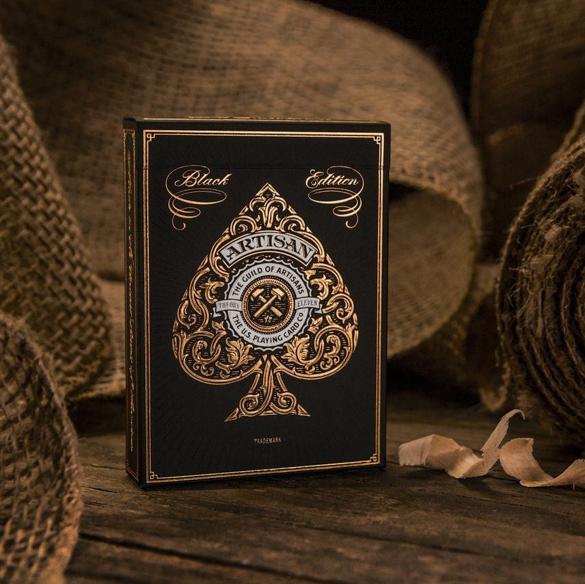 Playing card box with intricate design on a rustic wooden surface