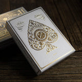 White and gold playing card box on a wooden surface