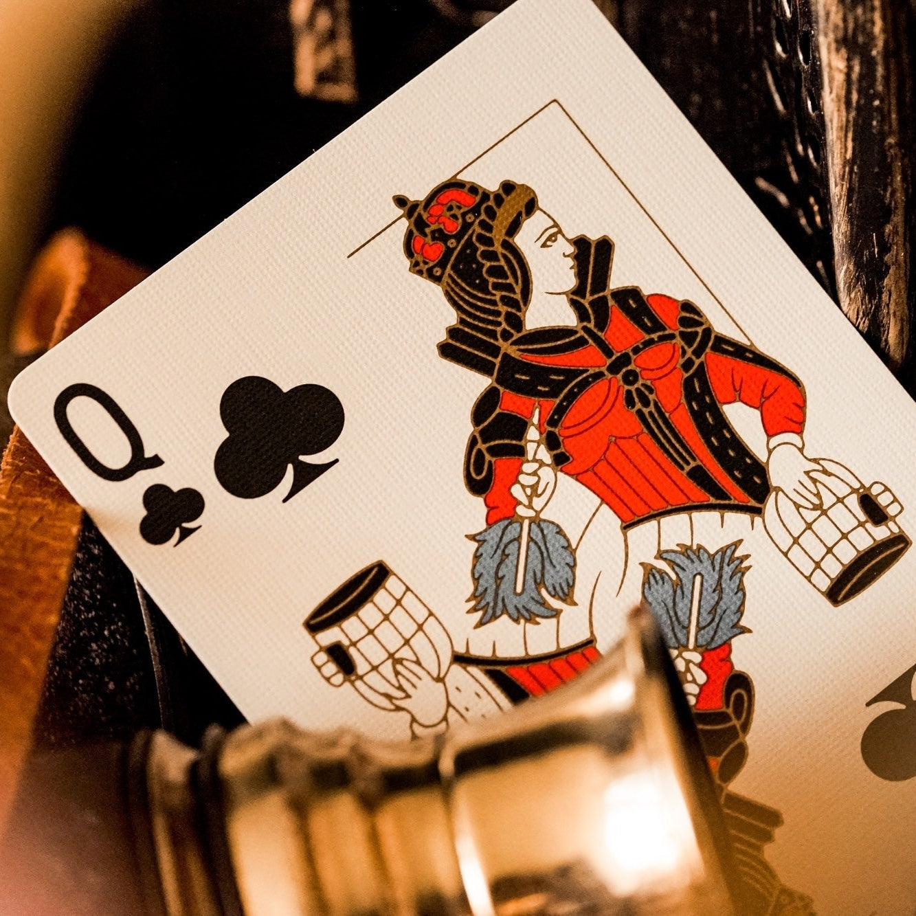 Playing card with Queen of Clubs design on a blurred background