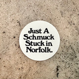 Screen printed vinyl sticker with black text on a white background reading "Just A Schmuck Stuck in Norfolk."