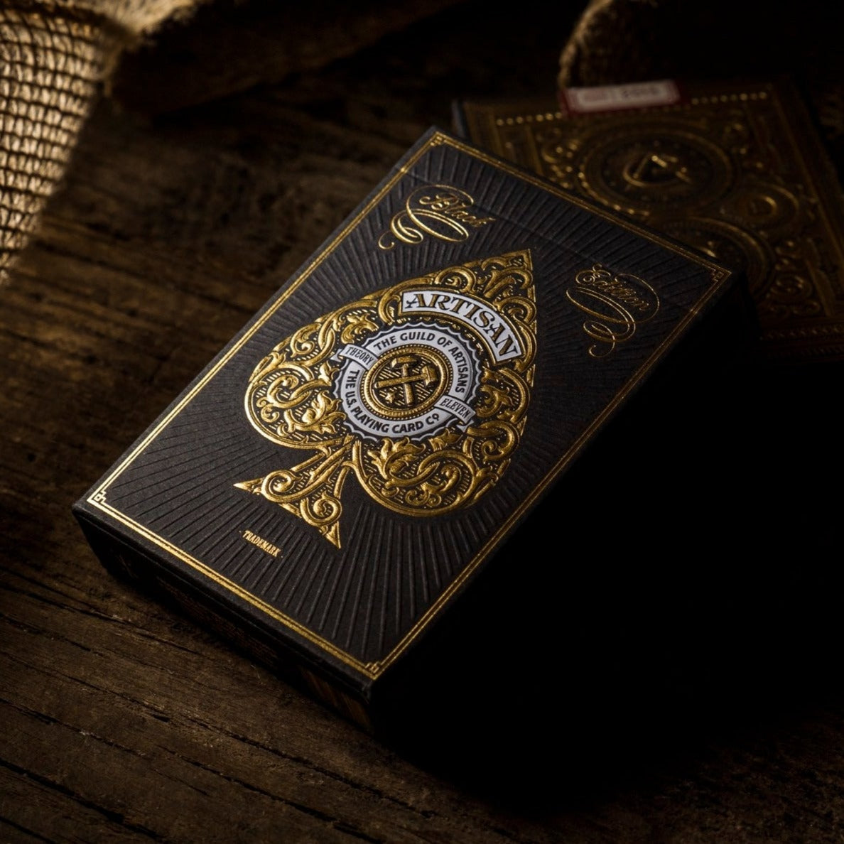 Playing cards with gold and black design on a wooden surface