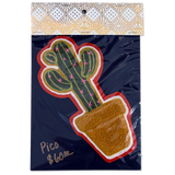 A packaged decorative patch featuring a green cactus in a brown pot with a red and white border, attached to a dark navy backing card with a patterned header. Handwritten text on the card reads 'Pico $6.
