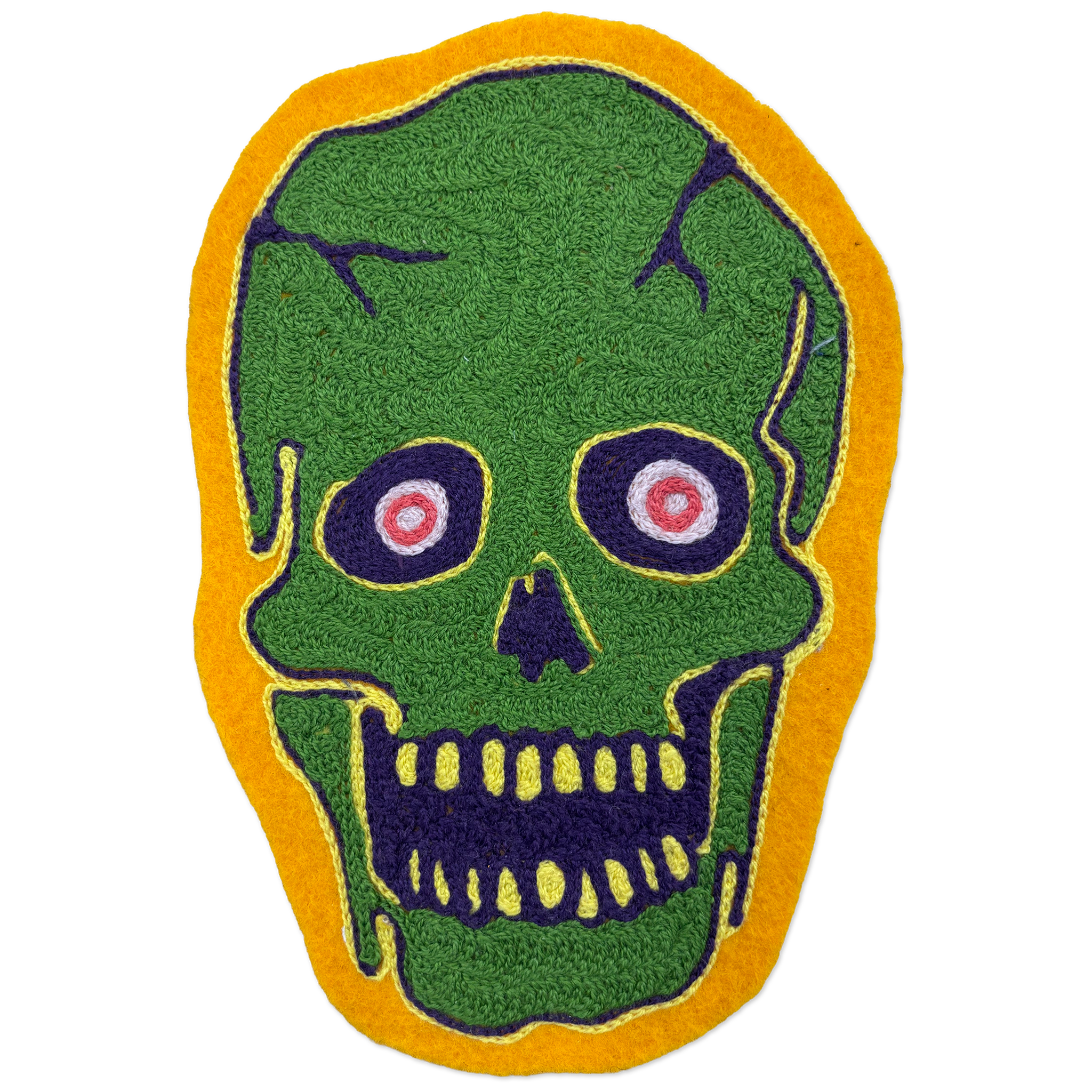 A green skull-shaped patch with a yellow border, featuring dark purple facial details and pink-and-white eyes, shown on a plain white background.