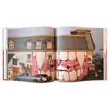 double-page spread of a photograph of a building with a mural painted on the side, depicting vampire teeth and pink roses