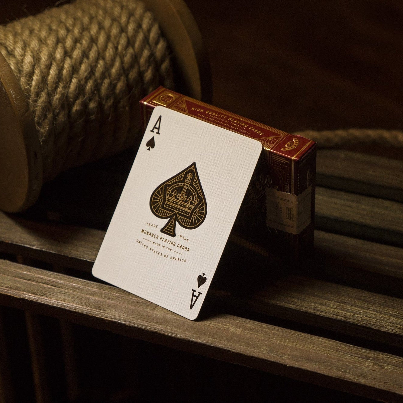 Playing card with ace of spades design on a wooden surface with rope