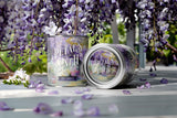 Two candles labeled 'Petals on the Path' with purple flowers in the background