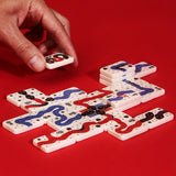 A hand placing a tile in the Snakes of Wrath game, on a red background