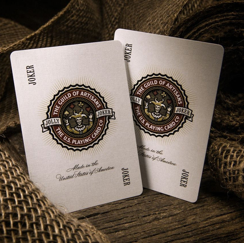 Two playing cards with a logo and text on a textured surface