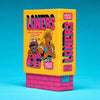 West Coast Loners card game box in bright yellow with pink and black lettering, featuring cartoon characters on the front, displayed on a pink brick-like base against a bright blue background.