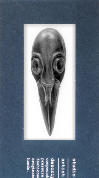 Decorative black graphite bird skull with a long beak on a white background
